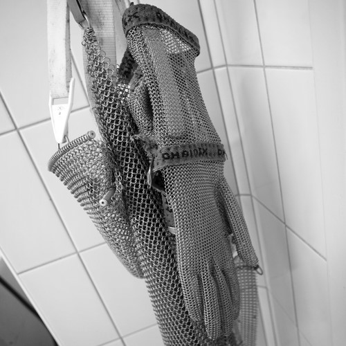 uitbeenhandschoen en schort hangend in slagerij-500x500