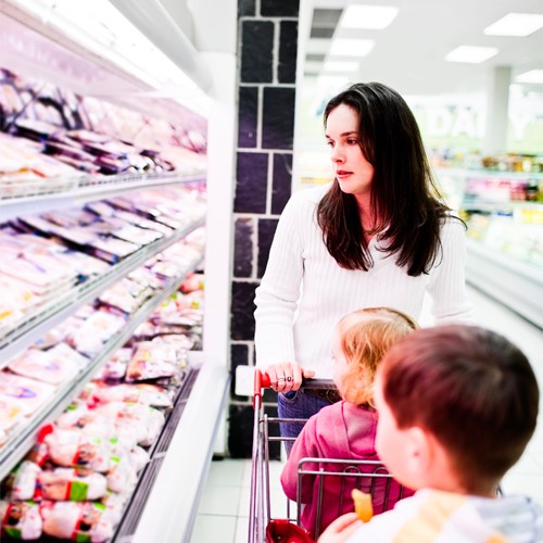 moeder met kinderen in winkelwagen kopen vlees in supermarkt-500